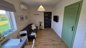 a living room with a couch and a green door at Dębowy Zakątek in Zarzecze