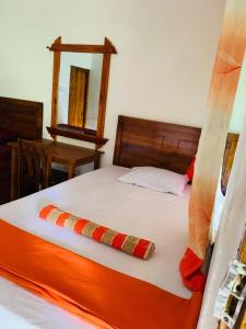 Una cama con un edredón naranja y blanco con una almohada. en Ella Forest Bath, en Ella 78 fotos más