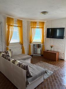 a living room with a couch and a flat screen tv at Vila Kula in Nin