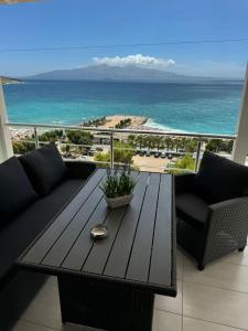a balcony with a table and a view of the ocean at Michal's Apartment in Sarandë