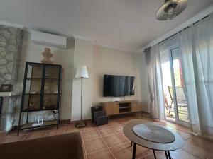 a living room with a television and a table at La Casa del Olivo en Montserrat - Valencia in Valencia