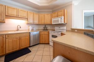 a kitchen with wooden cabinets and a white appliance at Lighthouse on the Bay 2109 condo in Orange Beach