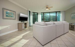a living room with a white couch and a flat screen tv at Lighthouse on the Bay 2109 condo in Orange Beach