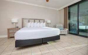 a bedroom with a large white bed and a chair at Lighthouse on the Bay 2109 condo in Orange Beach +49 photos