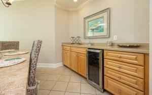 a kitchen with a counter and a table and a microwave at Lighthouse on the Bay 2109 condo in Orange Beach