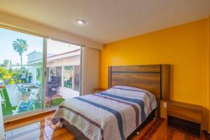 テミスコにあるCasa en Burgos, Cuernavacaのベッドと大きな窓のある寝室 +24枚の写真