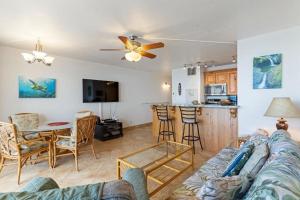 a living room with a couch and a table and a kitchen at Sugar Beach Resort, #524 in Kihei