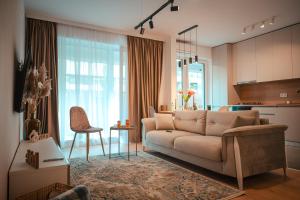 ein Wohnzimmer mit Couch und Küche in der Unterkunft Modern Apartment Atria Urban - North Bucharest, Sector 1 in Bukarest