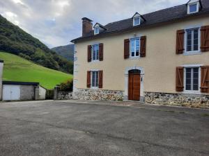 a large house with a driveway in front of a hill at Chambres d'hôtes Ferme LAPINE in Arthez-dʼAsson