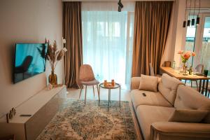ein Wohnzimmer mit Sofa und Fernseher in der Unterkunft Modern Apartment Atria Urban - North Bucharest, Sector 1 in Bukarest