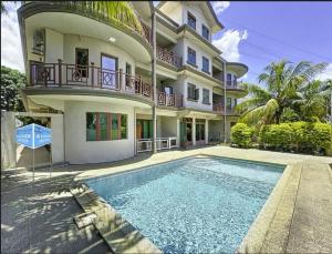 a house with a swimming pool in front of a building at Residence Acacia in Port Louis
