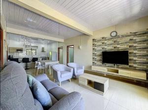a living room with a couch and a tv at Residence Acacia in Port Louis