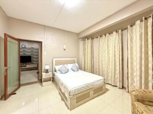 a bedroom with a bed and a television in it at Residence Acacia in Port Louis +21 photos