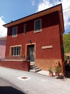 a red brick building with a door at Camerana La Casa Rossa in Camerana  +110 photos