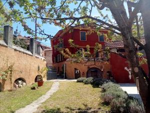 a red house with a tree in front of it at Camerana La Casa Rossa in Camerana 