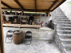 a room with a barrel and two chairs and stairs at Cabana de lemn Lacul Bicaz in Hangul