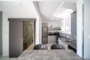 eine Küche mit einem Tisch und einigen Stühlen in der Unterkunft HiddenGems Residences 202 - The LXR Penthouse - Pool & Beach Steps in Paphos City + 29 Fotos