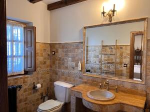 a bathroom with a sink and a toilet and a mirror at Apartamentos Villa Julieta in Ruente