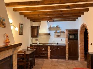 a kitchen with wooden cabinets and a table in a room at Apartamentos Villa Julieta in Ruente