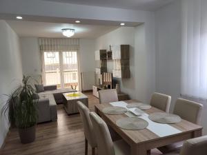 a dining room and living room with a table and chairs at Apartman Djuric in Golubac
