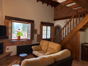 a living room with a couch and a staircase at Apartamentos Villa Julieta in Ruente