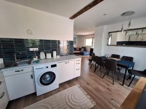 a kitchen with a washing machine and a dining room at Azur Corner in Zamárdi