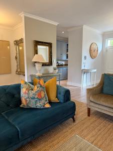 een woonkamer met een blauwe bank en een keuken bij Franschoek Lermitage Villa 33 Three Bedroom Lake View in Franschhoek