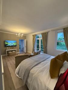 een slaapkamer met een groot bed en een tv bij Franschoek Lermitage Villa 33 Three Bedroom Lake View in Franschhoek