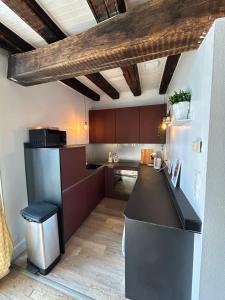 a kitchen with brown cabinets and a black counter top at Demeure de charme du 16ème siècle près de Sancerre in Ménétréol-sous-Sancerre +23 photos