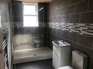 a bathroom with a shower and a toilet and a sink at 3 Bed Bungalow With Private Woods and HotTub in West Langdon +10 photos