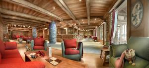 a living room with red and green chairs and a table at CGH Résidences & Spas Les Fermes de Ste Foy in Sainte-Foy-Tarentaise +22 photos