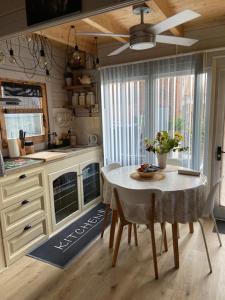 cocina con mesa y ventilador de techo en Tinyhouse Woody at the Water, en Zaandam