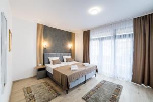 a bedroom with a bed and a large window at Aman Apartments in Sarajevo