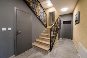 a hallway with a staircase with a metal door and a stairway with a door at Aman Apartments in Sarajevo
