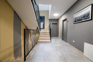 a hallway of a home with a staircase and a painting on the wall at Aman Apartments in Sarajevo +38 photos