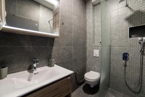 a bathroom with a sink and a toilet and a shower at Aman Apartments in Sarajevo
