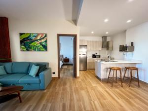 a living room with a blue couch and a kitchen at Oasis Retreat 2 Bedroom with Private Pool, Gated in Punta Cana
