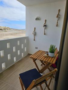 a table and chairs on a balcony with a view of the beach at Steps to the beach, comfortable in Caldera