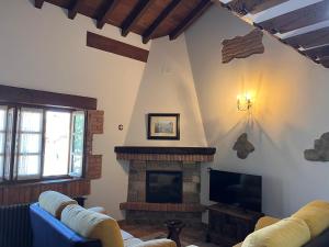 a living room with a fireplace and a tv at Apartamentos Villa Julieta in Ruente