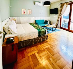 a bedroom with a bed and a couch and a table at Hotel Boutique Casa Noble in Santiago