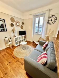 a living room with a couch and a tv at Appartement plein centre, lumineux et spacieux in Saint-Jean-de-Luz