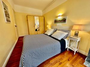 a bedroom with a bed with a black and white striped comforter at Appartement plein centre, lumineux et spacieux in Saint-Jean-de-Luz +10 photos