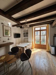 a dining room with a table and chairs in a room at Demeure de charme du 16ème siècle près de Sancerre in Ménétréol-sous-Sancerre