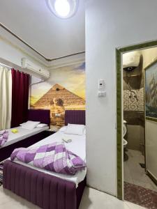 a hotel room with two beds and a bathroom at Jana Pyramids view inn in Cairo +235 photos