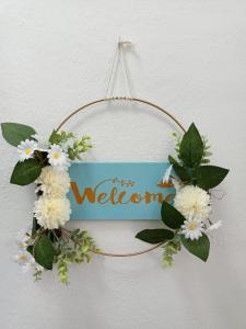 a wreath with flowers and a welcome sign on a wall at Casa Rural en Padules GR in Padules