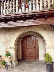 a building with a wooden door and a balcony at Apartamentos Villa Julieta in Ruente