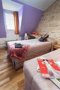 a hotel room with two beds and a stone wall at Le Montclair Montmartre by River in Paris