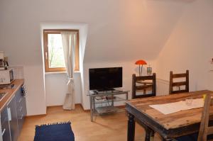 uma sala de estar com uma mesa e uma televisão em City Apartment Vasiri em Knittelfeld