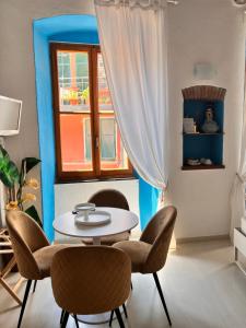 a table and chairs in a room with a window at La Polena Camere Vernazza - Visconti Apartment in Vernazza