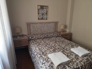 a bedroom with a bed with two nightstands and two lamps at Granja de San Antonio in Fresnedillas +39 photos